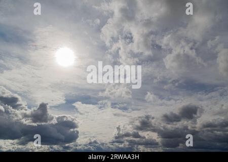 cielo blu con sole e nuvole miste su diversi livelli, sopra la vista dell'orizzonte Foto Stock