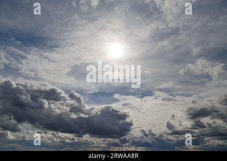 cielo blu con sole e nuvole miste su diversi livelli, sopra la vista dell'orizzonte Foto Stock