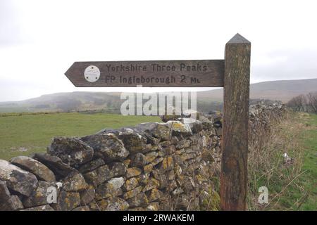 Wooden Signpost for Footpath to Ingleborough and the Yorkshire Three Peaks from Chapel-le-dale, Yorkshire Dales National Park, Inghilterra, Regno Unito. Foto Stock