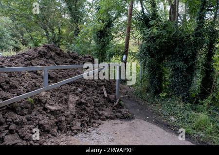 Mucchi di terra bloccano la strada per il pub Crooked House a Himley, dove un incendio scoppiò nel fine settimana in mezzo a circostanze inspiegabili, e che fu inaspettatamente demolito meno di due giorni dopo, facendo arrabbiare la gente locale l'11 agosto 2023 vicino a Dudley, Regno Unito. Il mistero rimane il motivo per cui questi tumuli di terra sono stati collocati qui e che hanno ostacolato gli equipaggi dei vigili del fuoco che assistevano all'incendio. La polizia sta indagando sulle circostanze dell'incendio come incendio doloso, e sta cercando di stabilire se la demolizione fosse lecita. L'aspetto distintivo della Crooked House è stato il risultato della cedimento minerario che ne ha causato uno Foto Stock