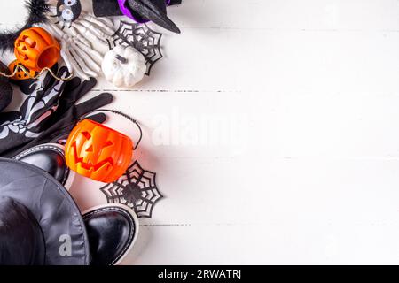 Preparativi per la festa di Halloween dei bambini, la tradizione del trucco o del dolcetto. Costume di Halloween tradizionale per bambini: Strega, fantasma, scheletro, accessori di zucca Foto Stock