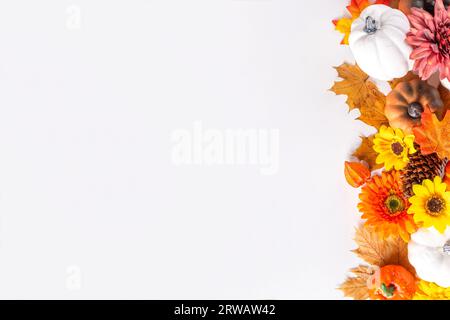 Vacanze autunnali e sconti. Biglietto di auguri per il giorno del Ringraziamento. Zucche multicolore, foglie autunnali e fiori, coni di ghianda, decorazioni bianche Foto Stock