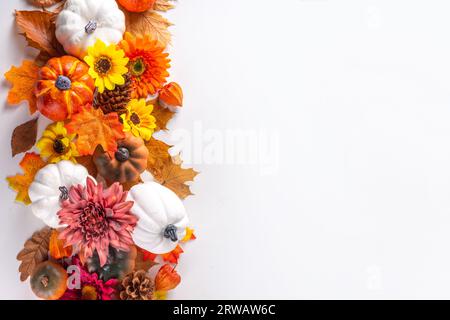 Vacanze autunnali e sconti. Biglietto di auguri per il giorno del Ringraziamento. Zucche multicolore, foglie autunnali e fiori, coni di ghianda, decorazioni bianche Foto Stock