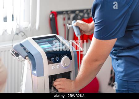 Fisioterapista medico utilizza attrezzature mediche per un trattamento efficace del dolore. Foto Stock