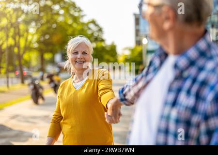 Coppia anziana innamorata che cammina in città Foto Stock