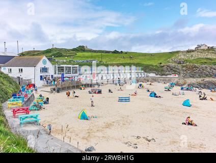 Turisti e escursionisti di un giorno sulla spiaggia sabbiosa di Porthgwidden a St Ives, in Cornovaglia, con la marea dell'Oceano Atlantico fuori in una giornata nuvolosa e soleggiata. Foto Stock