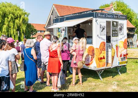 Una fila di persone che fanno la fila davanti a un furgone del gelato per comprare gelati in una calda giornata estiva in un evento a Sandwich, Kent. Foto Stock