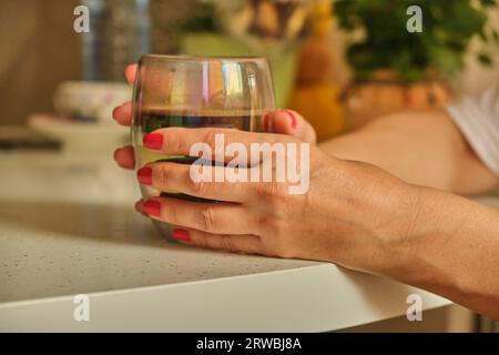 Donna che versa caffè caldo in tazza al mattino dalla pentola. Casalinga a casa, preparare caffè macinato fresco in cucina per colazione, bere, macinare cof Foto Stock