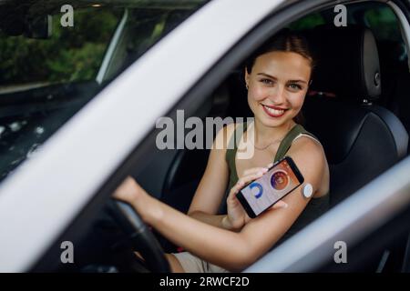 Donna con diabete che controlla il livello di glucosio nel sangue prima di guidare un'auto. Foto Stock