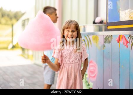 Bambina con caramelle di cotone rosa Foto Stock