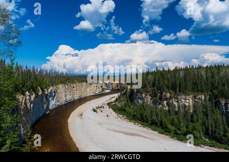 Lo splendido fiume Trout attraversa la Foresta Boreale mentre Thunderheads costruisce nei territori del Nord-Ovest, NT, Canada Foto Stock