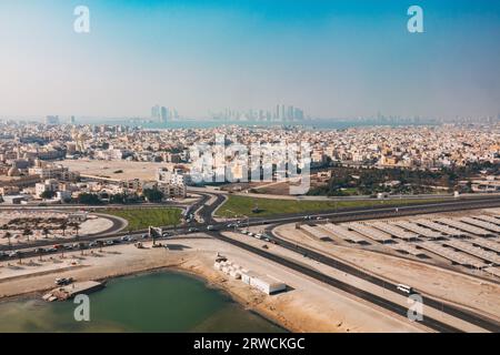Una vista aerea della cittadina di Muharraq, vicino all'Aeroporto Internazionale del Bahrain. La città di Manama può essere vista in lontananza dall'altra parte della baia Foto Stock