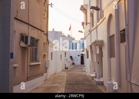 Le strette stradine e gli edifici bianchi caratteristici di Muharraq, una storica cittadina di pescatori del Bahrain Foto Stock