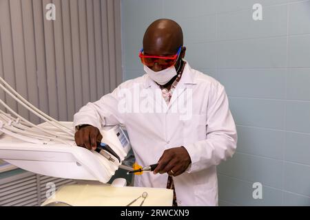 bel medico con attrezzature dentali nelle sue mani in una clinica dentale Foto Stock