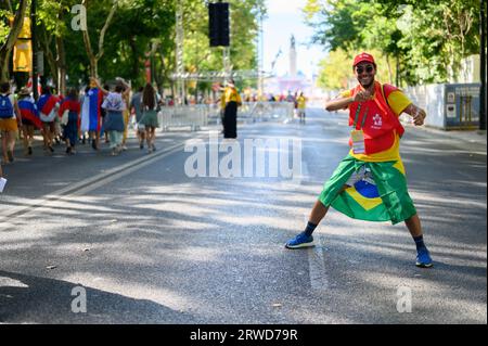 Un volontario brasiliano che dirige i greggi di pellegrini in cammino verso la Santa messa di apertura nel primo giorno delle Giornate Mondiali della Gioventù a Lisbona, Portogallo. Foto Stock