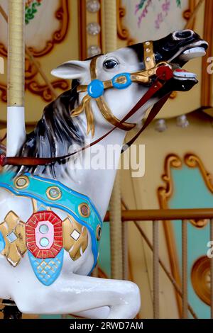 Primo piano di un cavallo a carosello di galoppo colorato della zona fieristica tradizionale montato su un carosello della zona fieristica spagnola sul fronte del porto a la Coruna. Foto Stock