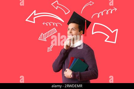 Studente di laurea maschile premuroso e molte frecce su sfondo rosso. Concetto di scelta Foto Stock