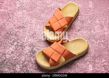 Eleganti infradito femminili su sfondo rosa grunge Foto Stock