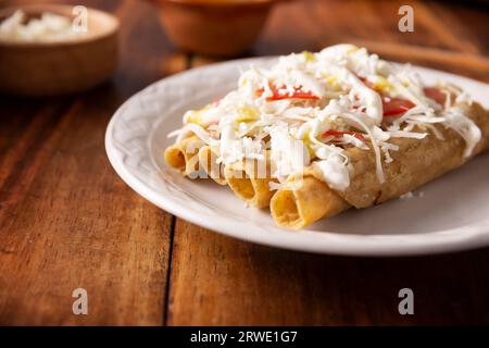 Taco Dorados. Il piatto messicano, noto anche come flautas, consiste in una tortilla di mais arrotolata con un po' di ripieno, comunemente pollo o manzo o opzione vegetariana Foto Stock