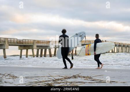 I surfisti sono pronti a entrare in acqua una mattina d'inverno all'alba a Jacksonville Beach, Florida. (USA) Foto Stock