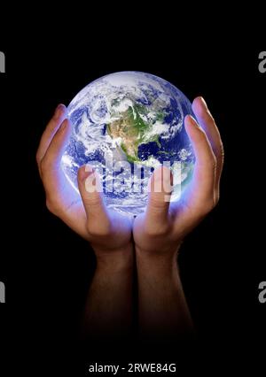 Un uomo che tiene in mano un pianeta Terra splendente. Immagine della Terra fornita dalla NASA Foto Stock