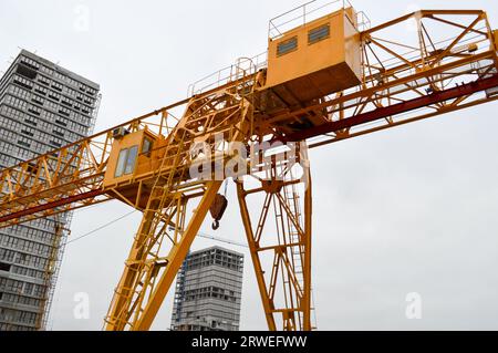 Struttura portante in ferro giallo pesante industriale stazionaria potente gru a portale di tipo a ponte su supporti per il sollevamento del carico su un m Foto Stock