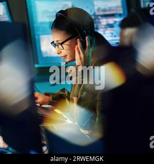 Centro di comando militare, cuffie e donna con comunicazione, computer e tecnologia. Sicurezza, sorveglianza globale e soldato con lavoro di squadra Foto Stock