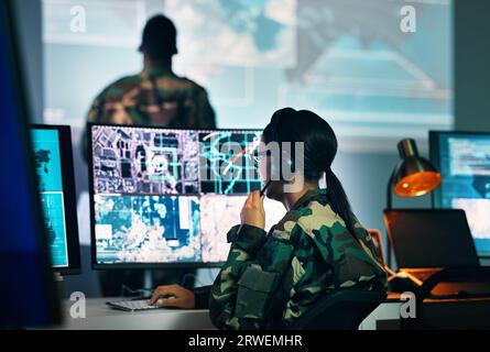 Centro di comando militare, schermo di computer e donna in sorveglianza, cuffie e tecnologia per la comunicazione. Sicurezza, mappa satellitare mondiale e soldato a. Foto Stock