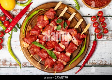 Spiedino di filetto di manzo su fondo di legno. Spiedino di filetto di manzo con salsa cruda con erbe e spezie. Vista dall'alto Foto Stock