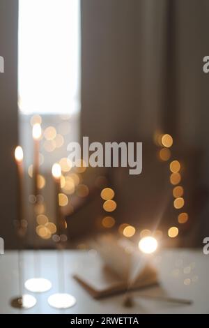 sfocatura sfondo astratto sfocato. concetto di vacanza, illuminazione e decorazione - bokeh delle ghirlande di natale sugli interni della casa beige Foto Stock