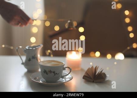 Interni accoglienti autunnali con una tazza di caffè e candele. Arredamento in stile Hygge. Halloween e il Ringraziamento Foto Stock