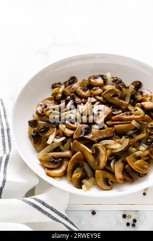 Funghi Champignon saltati con cipolla Foto Stock
