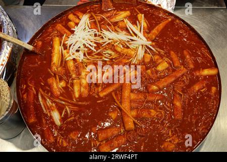 Cucina coreana al tradizionale mercato Gwangjang di Seoul, Corea del Sud. Tteokbokki: Piatto di torta di riso bollito. Foto Stock