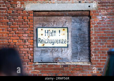 Jamel, Germania. 19 settembre 2023. "Halt Reichsgrenze" è scritto su un edificio di una proprietà nota alla polizia, dove le forze di polizia stanno conducendo un'operazione di perquisizione. Il ministro federale degli interni Faeser ha vietato l'associazione estremista di destra "Hammerskins Germany”, le sue propaggini regionali e la sottoorganizzazione "Crew 38”. Secondo il ministero, le forze di polizia hanno perquisito le case di 28 sospetti membri dell'associazione in dieci stati tedeschi la mattina presto. Credito: Jens Büttner/dpa/Alamy Live News Foto Stock