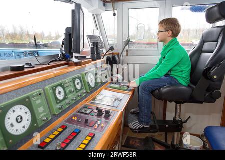 Giovane che lavora nella timoneria su una nave. Paesi Bassi 2014. vvbvanbree fotografie. Foto Stock