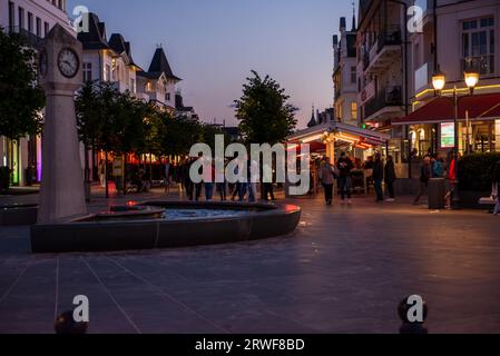 Binz auf Ruegen - 10 agosto 2023: Le persone camminano in un'area pedonale dopo il tramonto godendosi il tempo Foto Stock