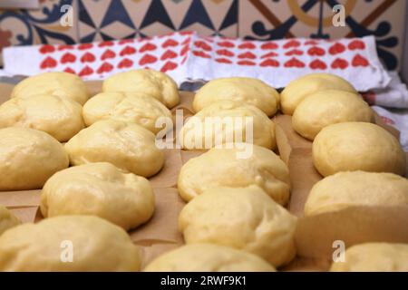 Preparare ciambelle rialzate fatte in casa con lievito - palle di impasto crude prima di friggere. Ciambelle polacche realizzate per le festività di Tlusty Czwartek (giovedì grasso) in Polonia. Foto Stock