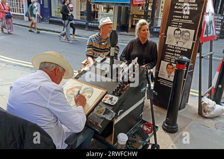 Artista che disegna caricatura di coppia per strada, York Foto Stock