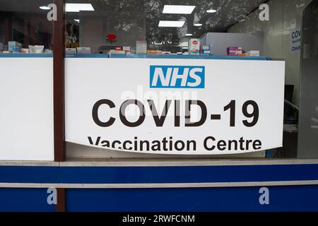 Harefield, Regno Unito. 18 settembre 2023. Un cartello del Centro di vaccinazione Covid-19 dell'NHS in una farmacia di Harefield. Le persone di età pari o superiore a 65 anni vengono sollecitate a ricevere i loro Booster Jabs Autumn Covid-19, poiché i casi continuano ad aumentare in tutto il Regno Unito. L'introduzione delle vaccinazioni autunnali è stata anticipata come precauzione contro una nuova variante di Covid altamente mutata chiamata BA.2,86. Molte persone di età inferiore ai 65 anni sono preoccupate di non essere più ammissibili per una vaccinazione di richiamo Covid-19 o un jab influenzale come sembra il governo sta tagliando i costi. Credito: Maureen McLean/Alamy Foto Stock