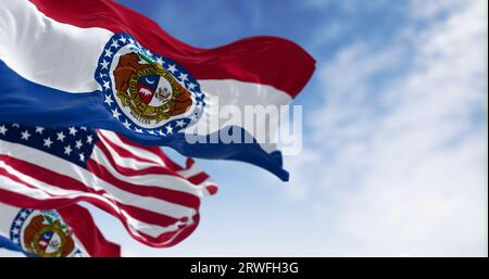 Primo piano delle bandiere dello stato del Missouri che sventolano con la bandiera nazionale americana in una giornata limpida. rendering dell'illustrazione 3d. Tessuto ondulato. Messa a fuoco selettiva Foto Stock