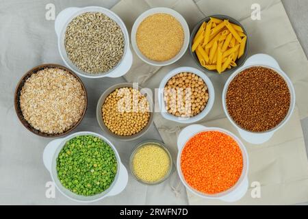 Set di prodotti biologici vegetariani in ciotole su sfondo bianco. Cibi biologici vegetariani. Stile country. Vista dall'alto. Foto Stock