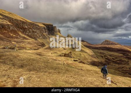 Un uomo solitario cammina attraverso il Quiraing sull'isola di Skye, in Scozia Foto Stock
