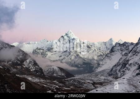 Incredibile Monte ama Dablam in Himalaya, nella zona del monte Everest, sotto il passo Cho la. Tramonto rosa sull'alto picco himalayano. Foto Stock