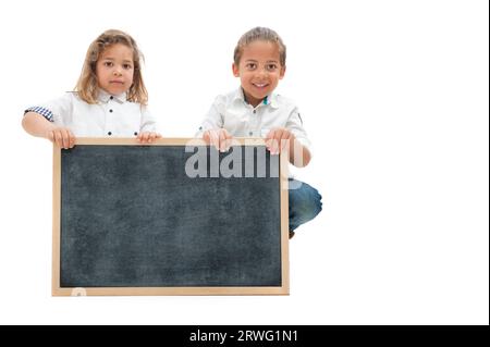 Inglese: Due bambini multietnici con i capelli lunghi tengono in mano una lavagna bianca su sfondo bianco Foto Stock