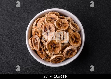 Fette rotonde di banana dolce su sfondo di cemento scuro. Ingredienti per preparare dolci vegani Foto Stock