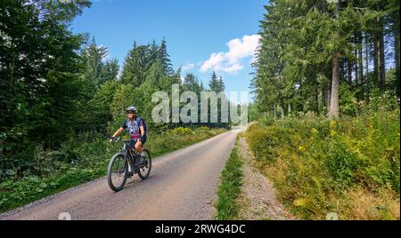 Bella donna anziana in mountain bike elettrica nella Foresta Nera tedesca vicino a Titisee-Neustadt, Baden-Württemberg, Germania Foto Stock