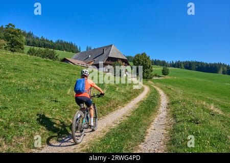 Bella donna anziana in mountain bike elettrica nella Foresta Nera tedesca vicino a Titisee-Neustadt, Baden-Württemberg, Germania Foto Stock