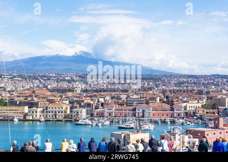 Passeggeri a bordo di una nave da crociera che arrivano al porto di Catania, Sicilia, Italia, Etna sullo sfondo. Foto Stock