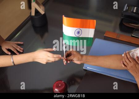 Felice Proud Principal, insegnante che dà personalmente, offrendo bandiera indiana come regalo, premio a uno studente per la sua promozione a scuola. Foto Stock