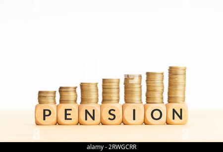 Parola pensione in blocchi di legno con monete impilate in pile crescenti. Ritirarsi nel concetto di ricchezza. Copia spazio Foto Stock